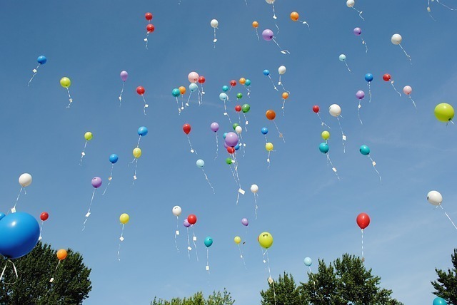 Luftballons steigen in den blauen Himmel