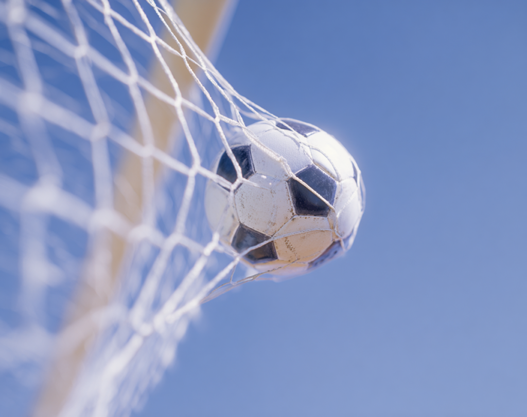Ein Fußball im Tornetz vor blauem Himmel als Symbol für Positionierung.