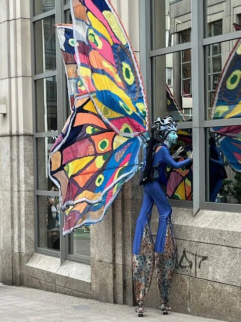 Mann auf Stelzen mit bunten Schmetterlingsflügeln beim Hansekulturfestival 2024.