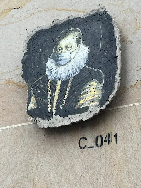 Kleine Plakette von mittelalterlich gekleidetem Mann mit Rüschenkrause und Corona-Maske