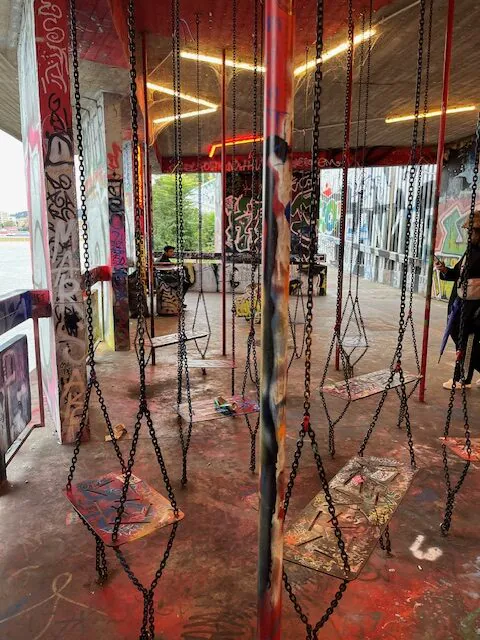 Kunsttunnel an der Moldau mit Graffiti und Schaukeln.